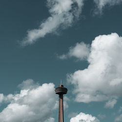Low angle view of skylon tower against cloudy sky