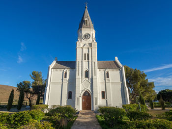 Low angle view of white dutch reformed church against blue sky, nieu-bethesda, south africa