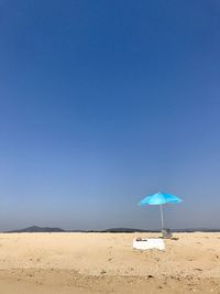 Scenic view of beach against clear blue sky