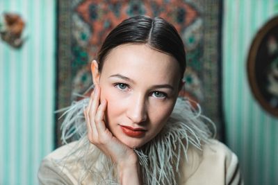 Close-up portrait of beautiful young woman against wall