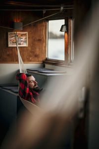 Man lying in hammock on boat