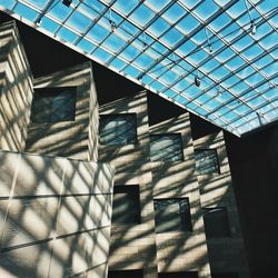 Low angle view of glass building against sky