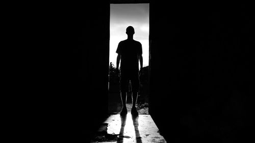 Rear view of silhouette man walking in corridor