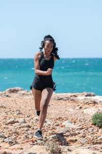 Full length of young woman standing on beach