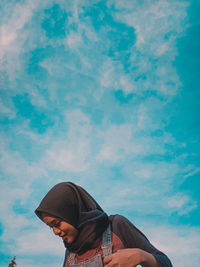 Portrait of young man standing against sky