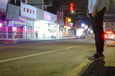 Low section of man on city street at night