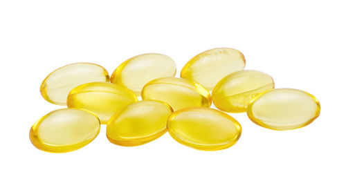 Close-up of cod liver oil pills over white background