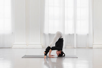 Side view of woman exercising in gym