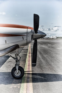 Close-up of airplane on runway against sky