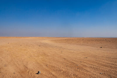 Scenic view of desert against clear blue sky