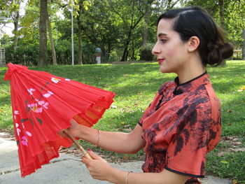 Side view of young woman looking away outdoors