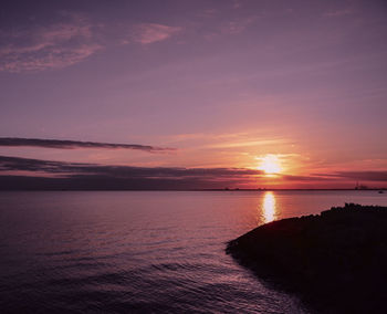 Scenic view of sea against romantic sky at sunset