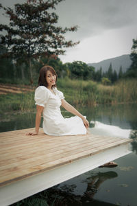 Rear view of woman sitting on boat in lake