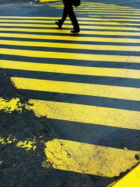 Low section of person walking on zebra crossing