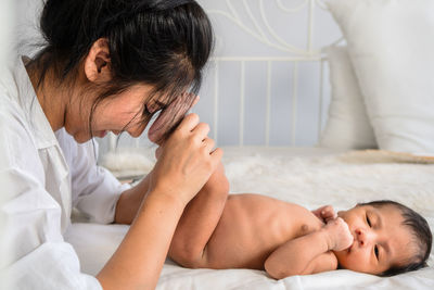 High angle view of baby lying on bed