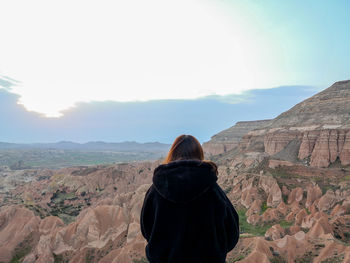 Rear view of woman looking at  red valley against sky