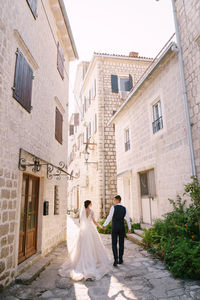 Rear view of couple walking on cobblestone street