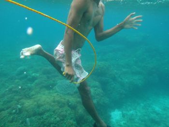 Man holding rope while swimming in sea