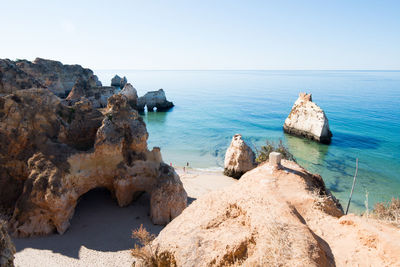 Rocks on beach against clear sky