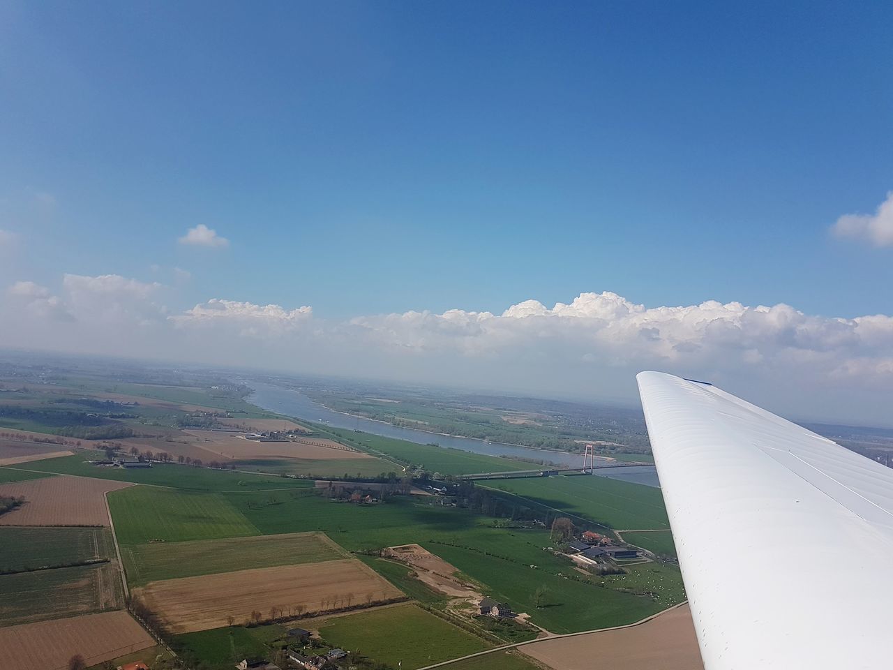 AERIAL VIEW OF AIRPLANE WING OVER FIELD