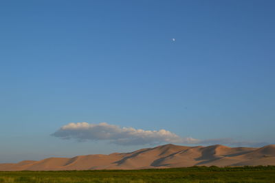 Scenic view of field against blue sky