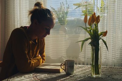 Young woman on table at home