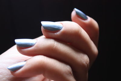 Close-up of woman hand over black background