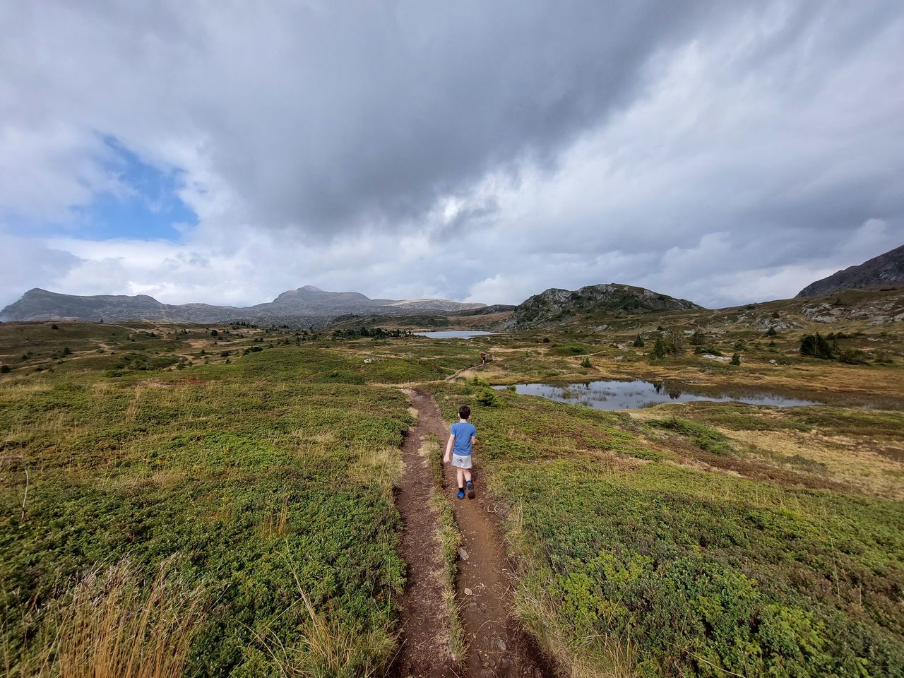 rear view of people walking on landscape against sky