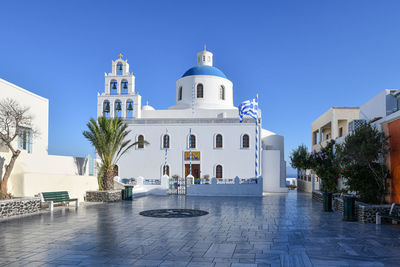 View of swimming pool by building against clear blue sky