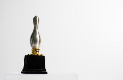 Close-up of electric lamp on table against white background