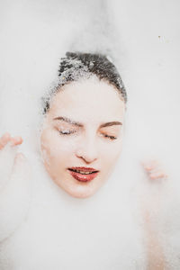 Close-up of young woman with eyes closed in bathroom