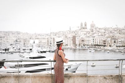 Rear view of woman standing by railing