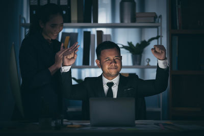 Man and woman using mobile phone in office