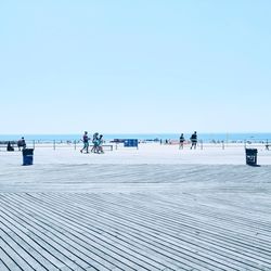 People on beach against clear sky