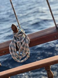 High angle view of rope tied to railing of boat in sea