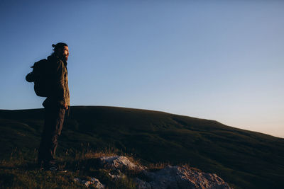 Man standing on rock against clear sky