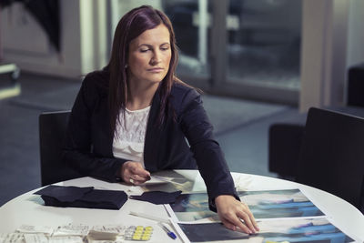 Businesswoman working on photographs in office