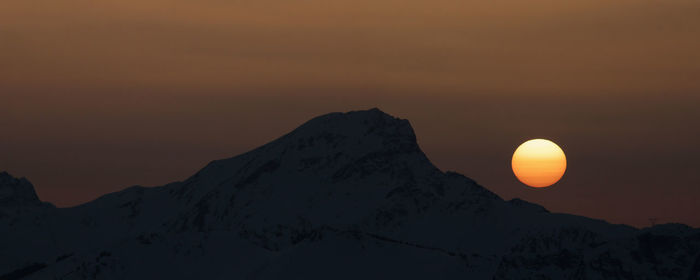 Scenic view of snowcapped mountains against sky during sunset