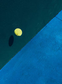 High angle view of yellow ball in blue water