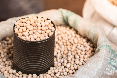 Close-up of beans with container in sack