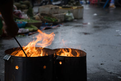 Midsection of person with fire on barbecue grill