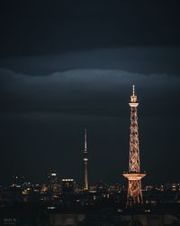 Illuminated buildings in city against sky at night