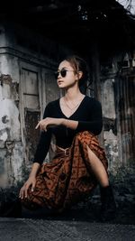 Woman wearing sunglasses sitting outdoors