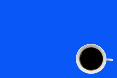 Directly above shot of coffee cup against blue background
