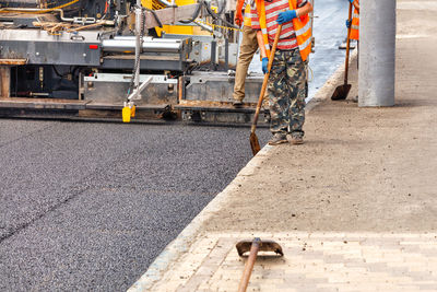 Paving fresh asphalt with industrial road equipment.