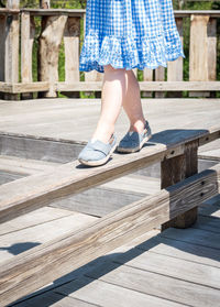 Low section of woman walking on wooden floor