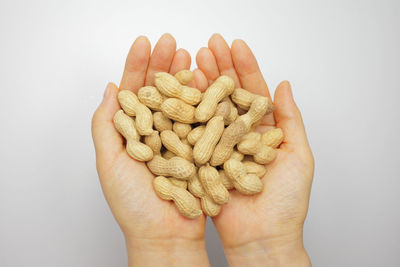 Close-up of hand holding bread against white background