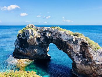 Rock formation in sea against sky