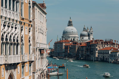 Boats in canal amidst buildings in city