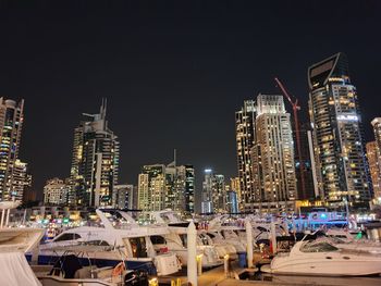 Illuminated buildings in city against sky at night